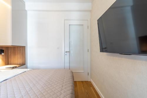 a bedroom with a bed and a flat screen tv at Park Vila Apartments in Belgrade