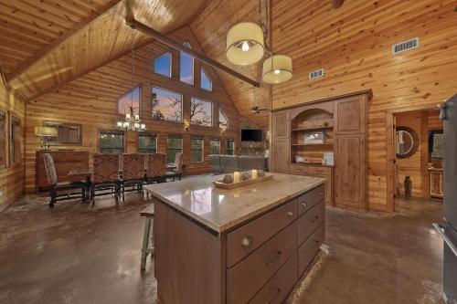 a large kitchen and dining room of a log cabin at NEW Prime Cabin Hot Tub-Firepit-Safari Sleeps 8 in Broken Bow