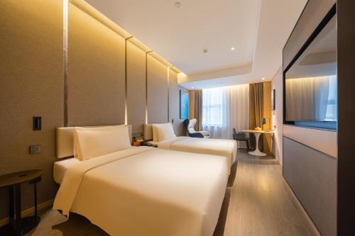a hotel room with two beds and a television at Atour Hotel Beijing Asian Games Village National Convention Center in Beijing