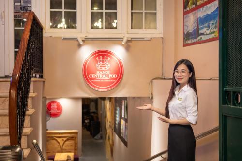 a woman standing in front of a building with a sign at Hanoi Central Pod in Hanoi