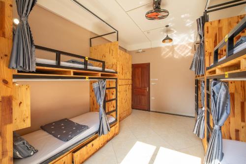 a room with three bunk beds and a hallway at Hanoi Central Pod in Hanoi