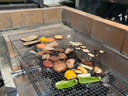 a grill with meat and vegetables on it at ハートリサイデェンス 河津 in Kawazu