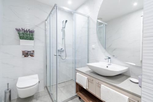 a white bathroom with a sink and a shower at Park Vila Apartments in Belgrade