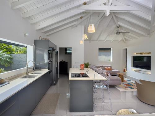 a kitchen and living room with white ceilings at Villa Jardin secret de la boucan - OFFRE SAISONNIERE ! in Sainte-Rose