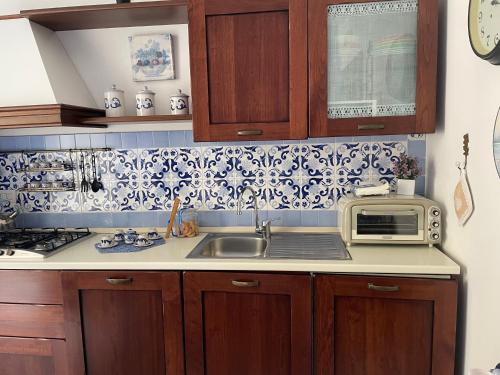 une cuisine avec un évier et un micro-ondes dans l'établissement B&b Isabel, à Salerne