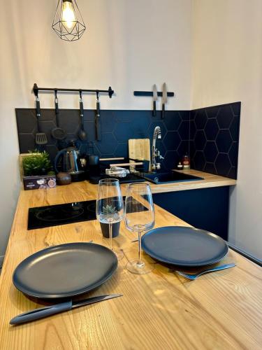 Beautiful Modern Studio في قرقشونة: طاولة خشبية عليها طبقان وكؤوس نبيذ