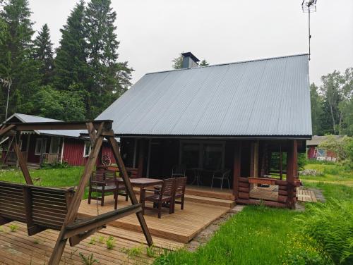 a cabin with a wooden deck with a table and chairs at Merikarviantupa1 in Pori