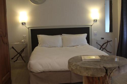 a bedroom with a bed and a table with a book on it at Logis Hôtels Restaurant Les 3 Rois in Issoudun