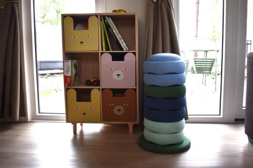 a stack of toys in a room with a book shelf at Boshuisje - Bos en Bliss in Haarle
