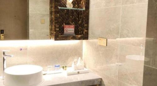 a bathroom with a sink and a mirror at Excemon Beach Hotel Beihai in Beihai