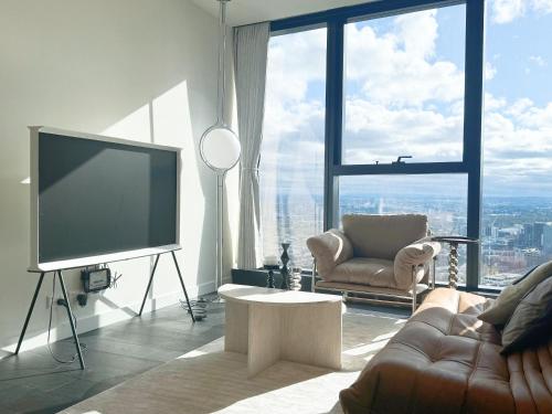 a living room with a television and a couch and a chair at Mel Stylish living in Melbourne