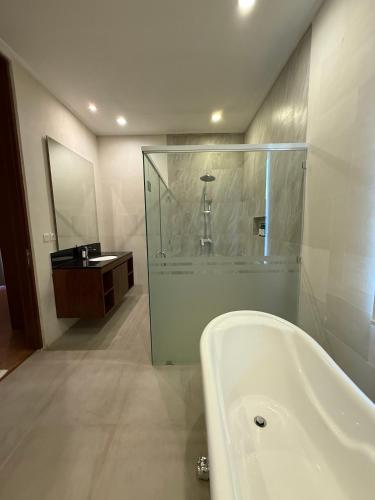 a bathroom with a bath tub and a sink at Avela bali villa in Kerobokan