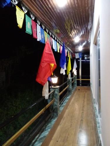 a hallway with prayer flags hanging from a ceiling at Sherpa's Homestay in Kurseong