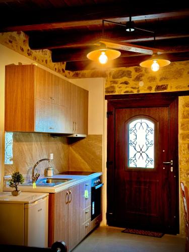 a kitchen with a wooden door and a window at Hercules Traditional Houses in Gálipe