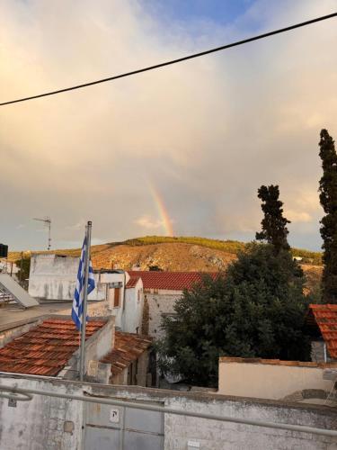 a rainbow in the sky over buildings with a flag at Hercules Traditional Houses in Gálipe