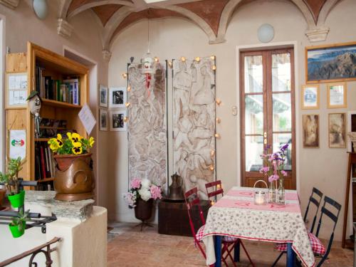 a dining room with a table and a room with flowers at B&B Contrada Lunga in Abbadia Lariana