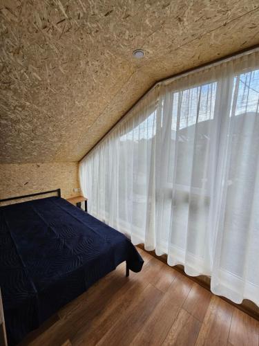a bedroom with a bed and a large window at AralanjINN in Aparan