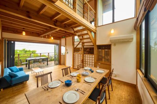 a dining room with a large wooden table and chairs at Suite Villa Ocean View Atami Shizenkyo in Atami