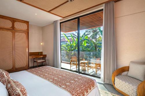 a bedroom with a bed and a large window at TUI BLUE Berawa Hotel and Villas in Canggu