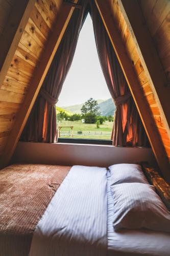 a bed in a tent with a window at Natures Escape Kozarica in Šavnik