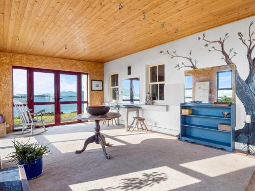 a room with a blue dresser and a table at Suantrai Cottage in Roundstone