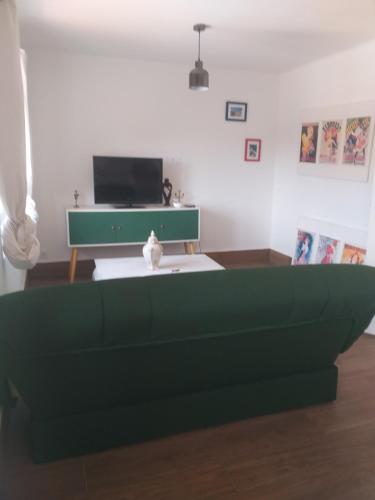 - un salon avec un canapé vert et un bureau dans l'établissement appartfa, à La Celle-sous-Gouzon