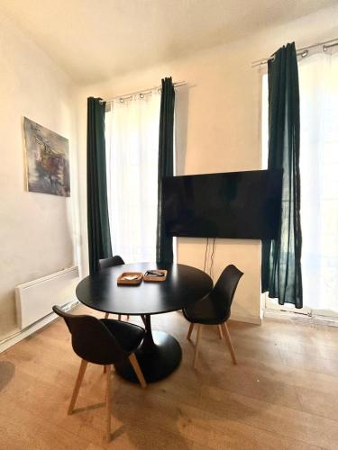 - un salon avec une table, des chaises et un piano dans l'établissement Central Charmant T2 4P Meublé et équipé Cours Julien Marseille, à Marseille