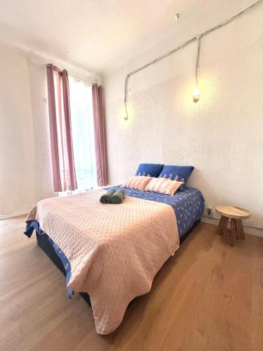 - une chambre avec un lit avec des draps bleus et une table dans l'établissement Central Charmant T2 4P Meublé et équipé Cours Julien Marseille, à Marseille