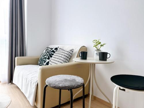 ein Schlafzimmer mit einem Bett, einem Tisch und einem Stuhl in der Unterkunft Wonderful Stay BTS Ratchayothin in Bangkok