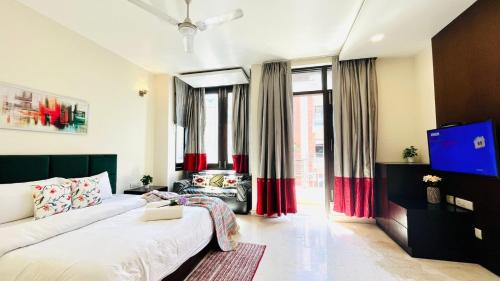 Un dormitorio con una cama y un televisor en una habitación. en Olive Service Apartments - Greater Kailash, en Nueva Delhi