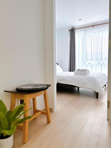 a bedroom with a bed and a table and a bed sidx sidx sidx at Wonderful Stay BTS Ratchayothin in Bangkok