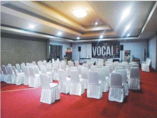 a room with white chairs and a red carpet at Fafa Hill Hotel and Resort in Bogor