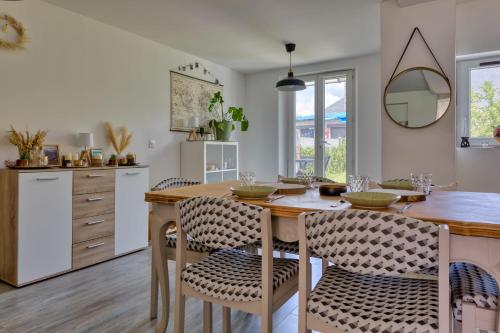 une cuisine avec une table et des chaises en bois dans l'établissement La Kase Dali jolie maison de ville avec jardin, à Grand-Couronne