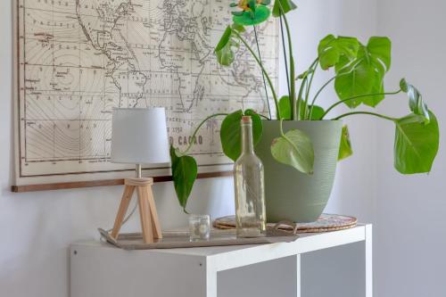 une table avec un vase et une plante sur elle dans l'établissement La Kase Dali jolie maison de ville avec jardin, à Grand-Couronne
