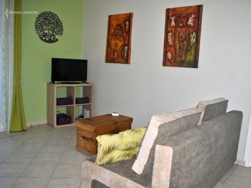 a living room with a couch and a tv at CoCoKreyol - " GRENADINE " in Les Trois-Îlets