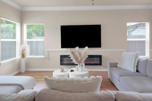 a living room with a couch and a tv at Spacious Home-Queen Suite-Game room-Movie room in Austin