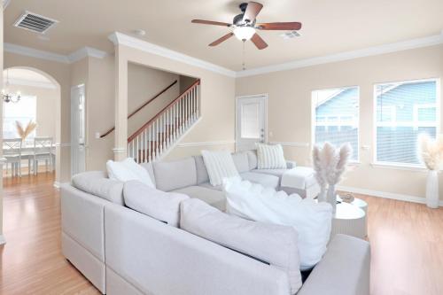 a living room with white furniture and a ceiling fan at Spacious Home-Queen Suite-Game room-Movie room in Austin