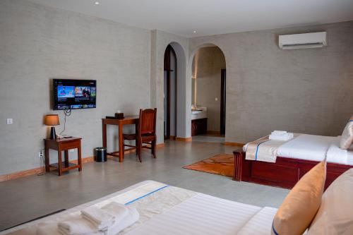 a hotel room with two beds and a television at Sokchea Kampot Hotel in Kampot
