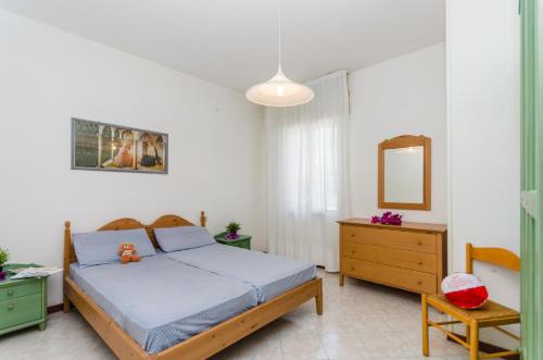 1 dormitorio con cama, tocador y espejo en Condominio Brionetta, en Bibione