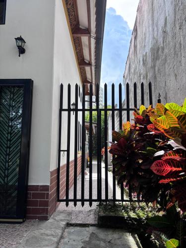 a black fence with flowers in front of a building at El susurro del agua casa blanca exclusiva natural in Ibagué