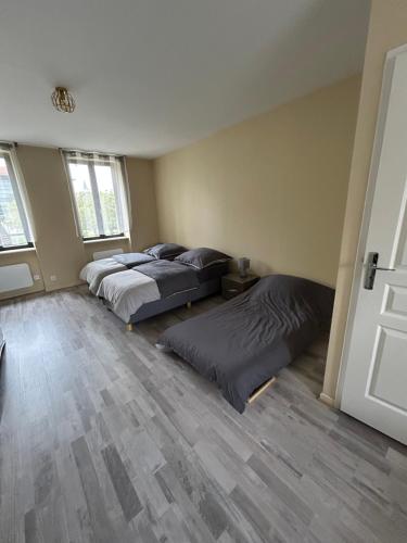 deux lits dans une chambre avec parquet dans l'établissement Studio le Saint Cosme, à Chalon-sur-Saône