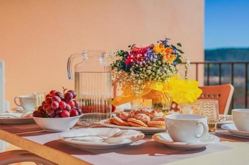 a table with plates of food and a vase of flowers at Estrela Apartment by Moje Holiday in Luz