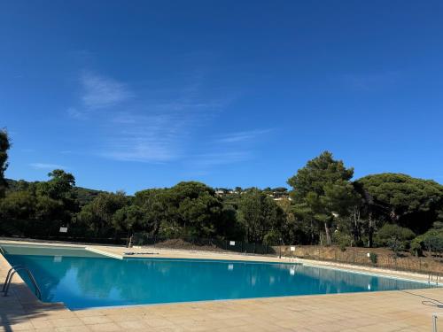 une piscine bleue avec des arbres en arrière-plan dans l'établissement Mas de Gigaro Eden View St Tropez, à La Croix-Valmer