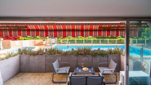 un patio avec une table et des chaises à côté d'une piscine dans l'établissement Cannes plage - avec terrasse, vue, mer, piscine, plage, garage, à Cannes