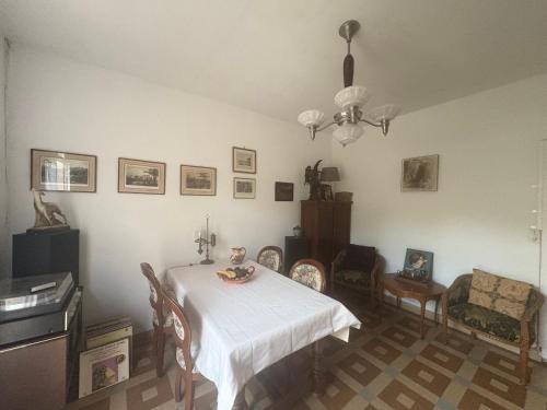 une salle à manger avec une table et des chaises blanches dans l'établissement Maison bord de plage, à Saint-Michel-Chef-Chef