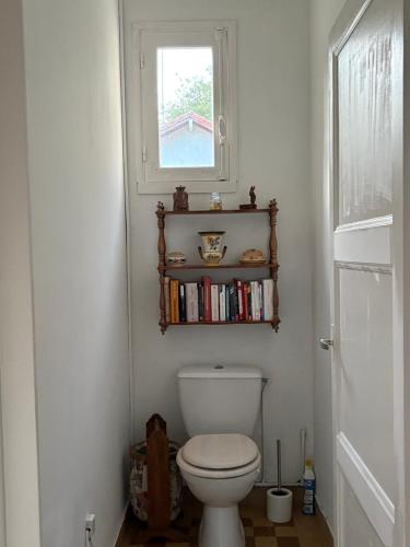 une salle de bain avec toilettes avec fenêtre et étagère dans l'établissement Maison bord de plage, à Saint-Michel-Chef-Chef