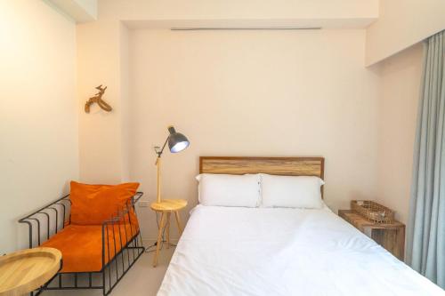 a bedroom with a bed and a chair at 寵物友善-無門禁24小時進出-水母漂民宿-免費停車 in Toucheng