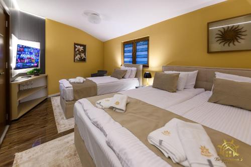 a hotel room with two beds and a television at Vodenica 3 Rooms in Duračka Reka