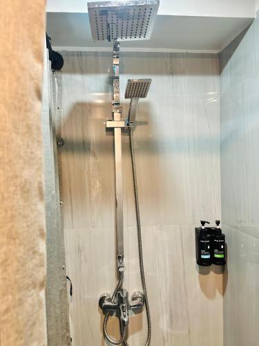 a bathroom with a shower with a hose at Traveler's Nest near Airport, Netflix, Stylish, Cozy with swimming pool in Lapu Lapu City