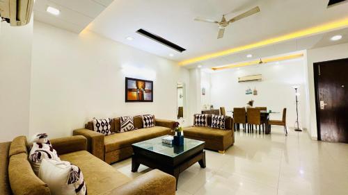 a living room with couches and a table at Olive Service Apartments - Greater Kailash in New Delhi